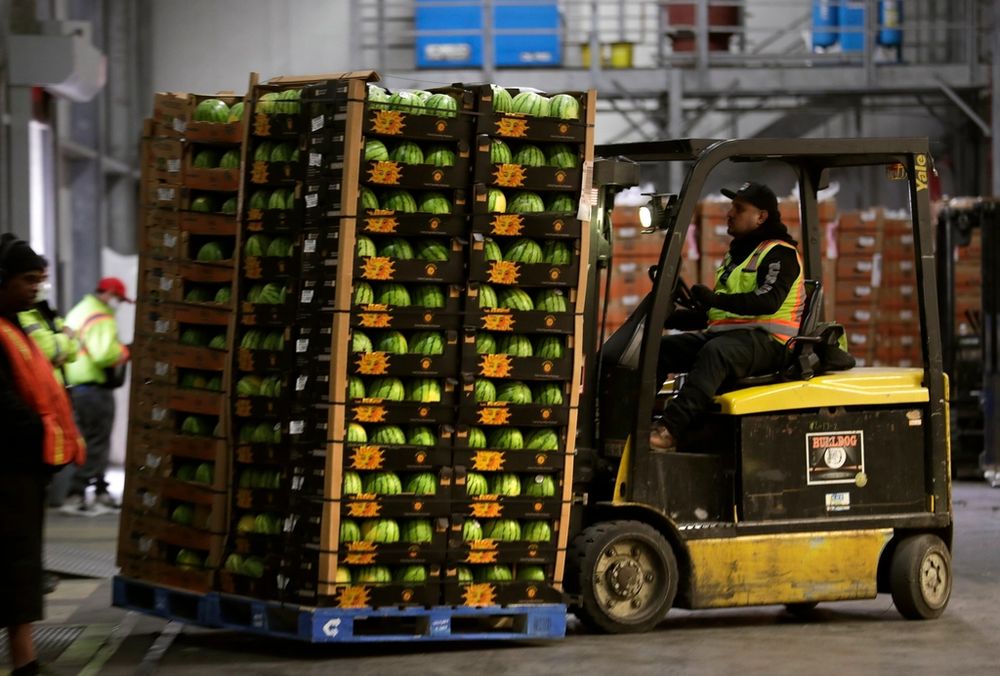 Heftruck verplaatst een volle pallet in een distributiecentrum